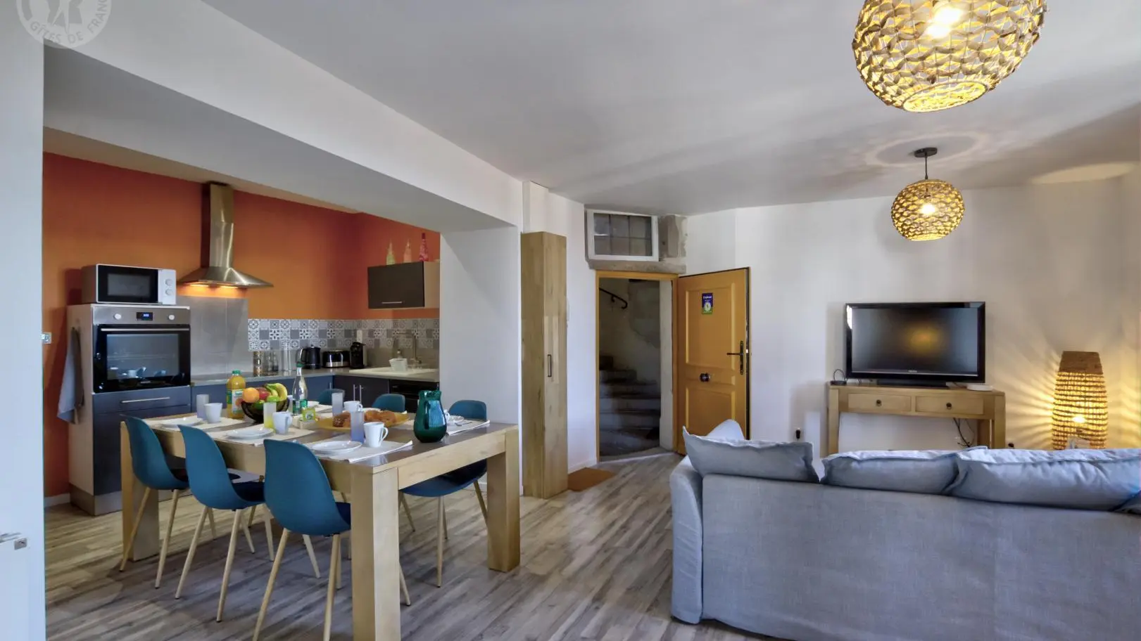 Pièce à vivre avec cuisine ouverte sur l'espace repas et le salon détente.