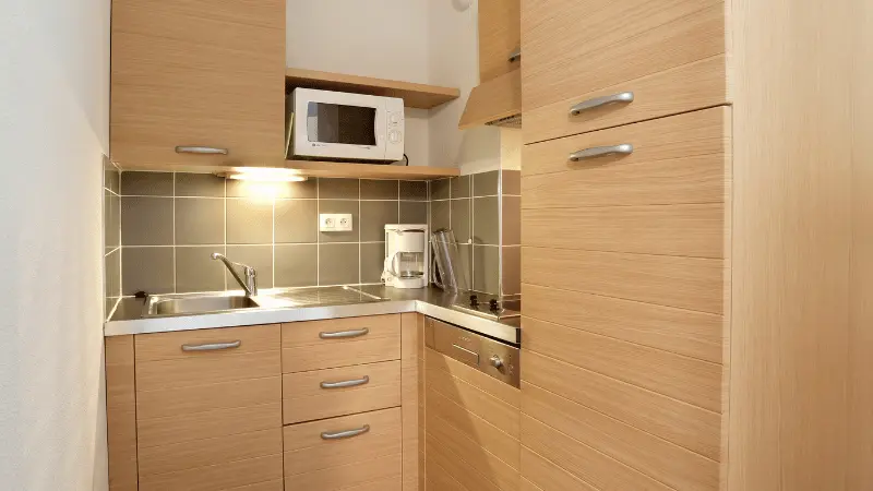 Kitchenette in a housing for 2 to 6 people, equipped with a microwave, a coffee machine, and an induction hob