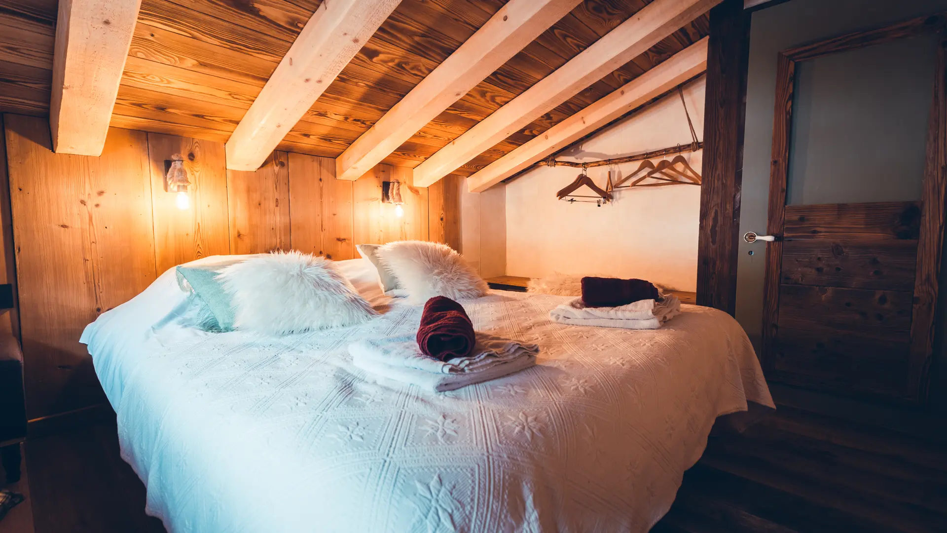 Chambre avec un grand lit, poutres apparentes