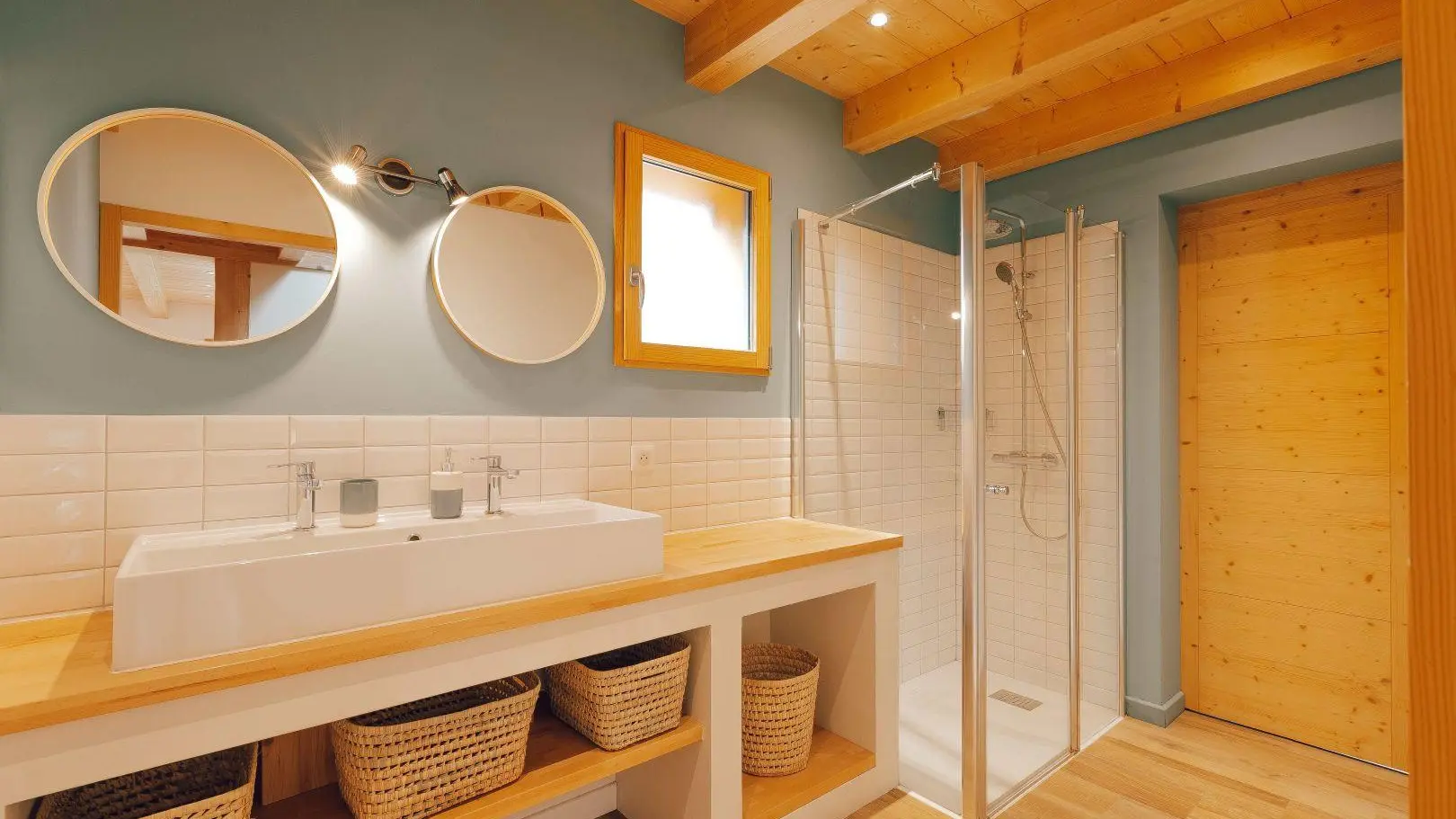 La salle de bain est équipée d'une large vasque et d'und douche.