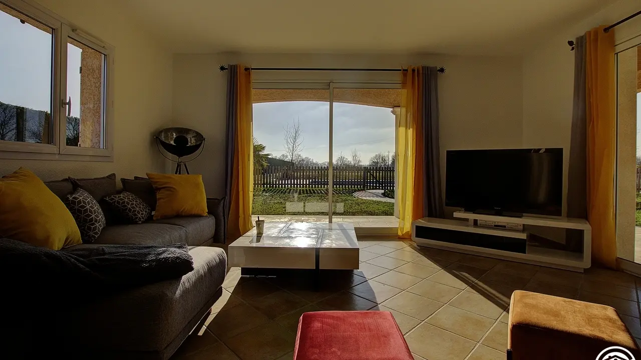 Le salon baigne de lumière grâce à ses baies vitrées.