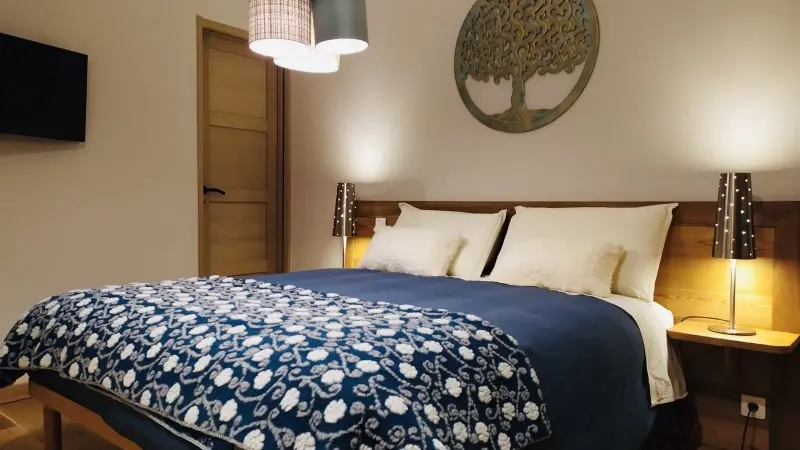 Chambre à coucher avec lit double, décoration en bois et TV