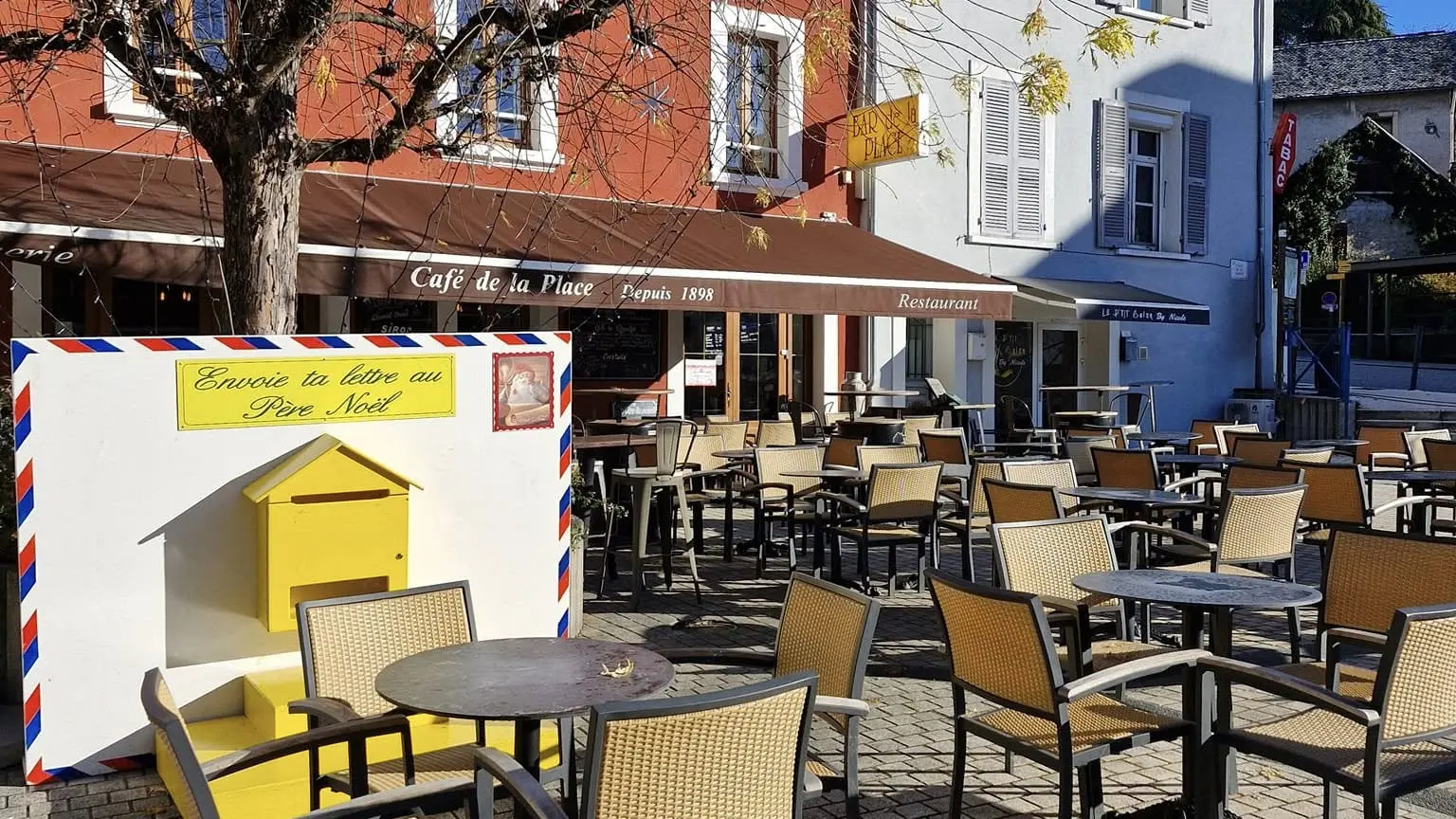 Terrasse de café ensoleillée avec un ciel bleu en fond.