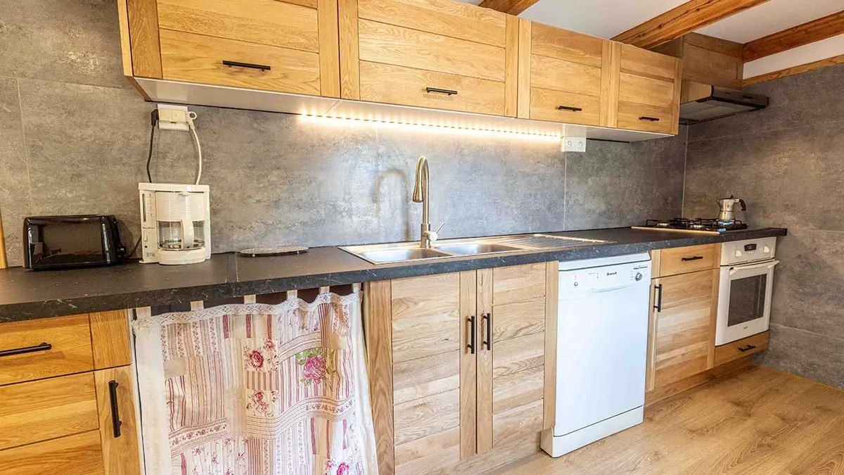 Cuisine moderne et lumineuse avec plaques au gaz, ameublement bois, parquet au sol