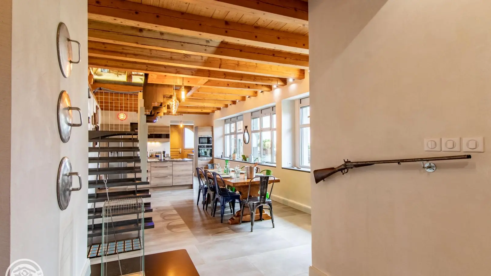 Vue sur espace repas, cuisine et accès étage (poêle à bois ajouté depuis la prise de vue)