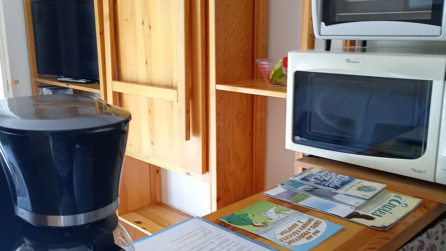 Séjour lumineux avec table à manger rétractable, TV, ameublement bois