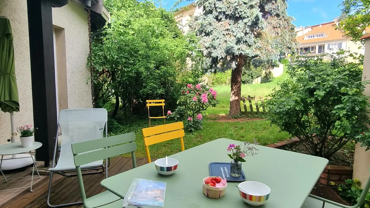 Terrasse privative avec son jardinet fleuri et arboré.