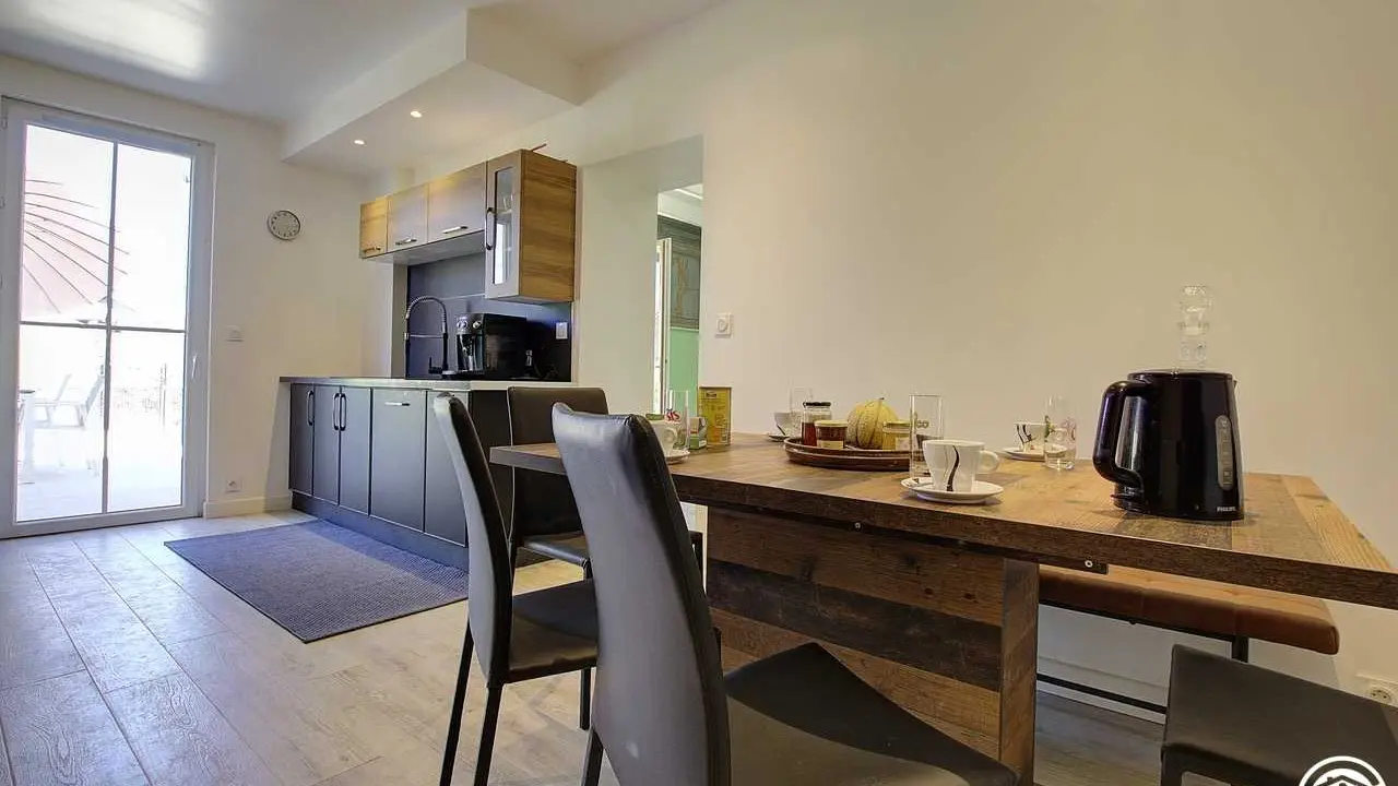 La cuisine et son espace repas, tout en longueur, avec accès direct  sur la terrasse.