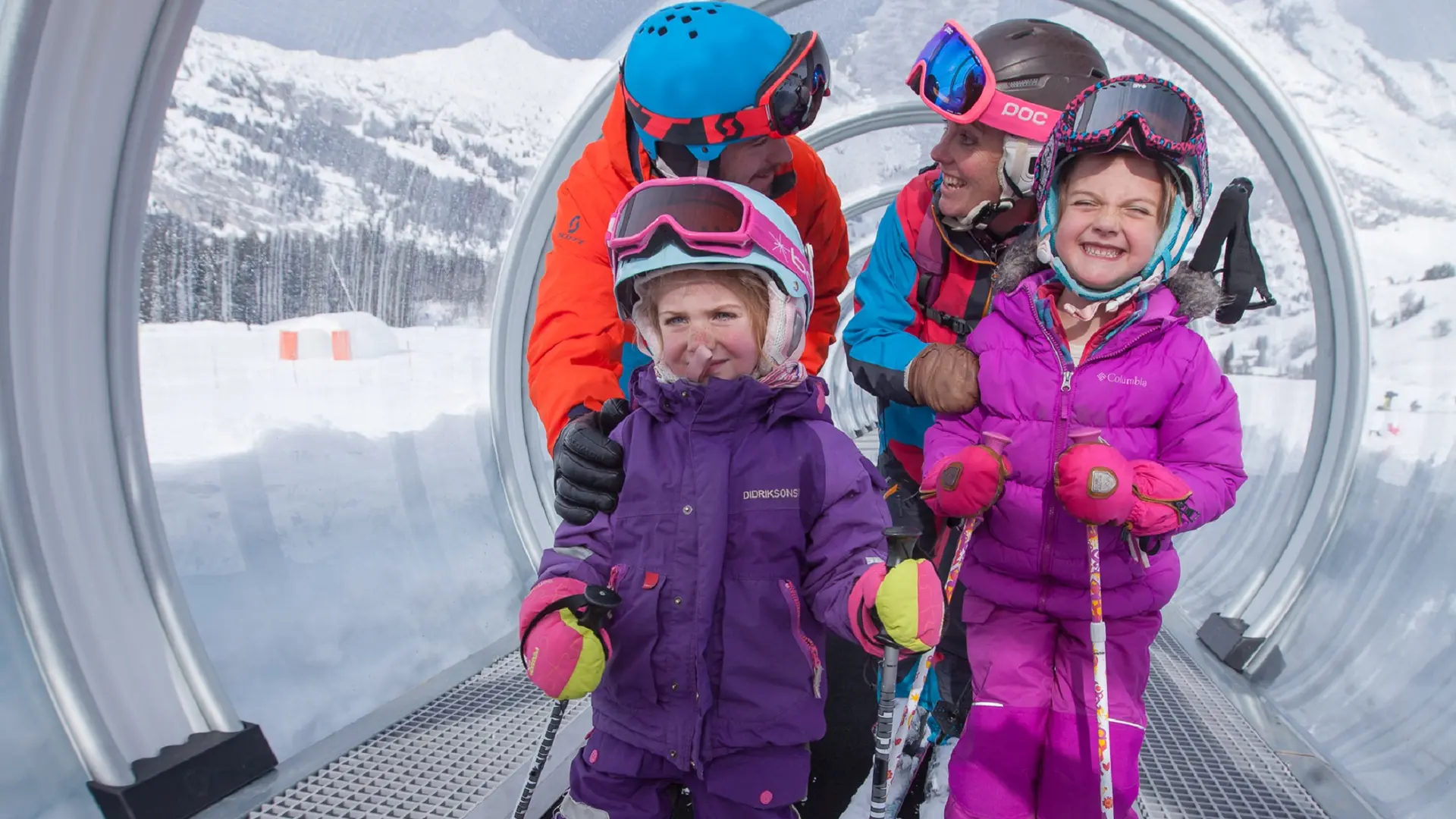 Famille sur le tapis de l'Alpage Express, sur les espaces débutants du domaine skiable du Grand-Bornand