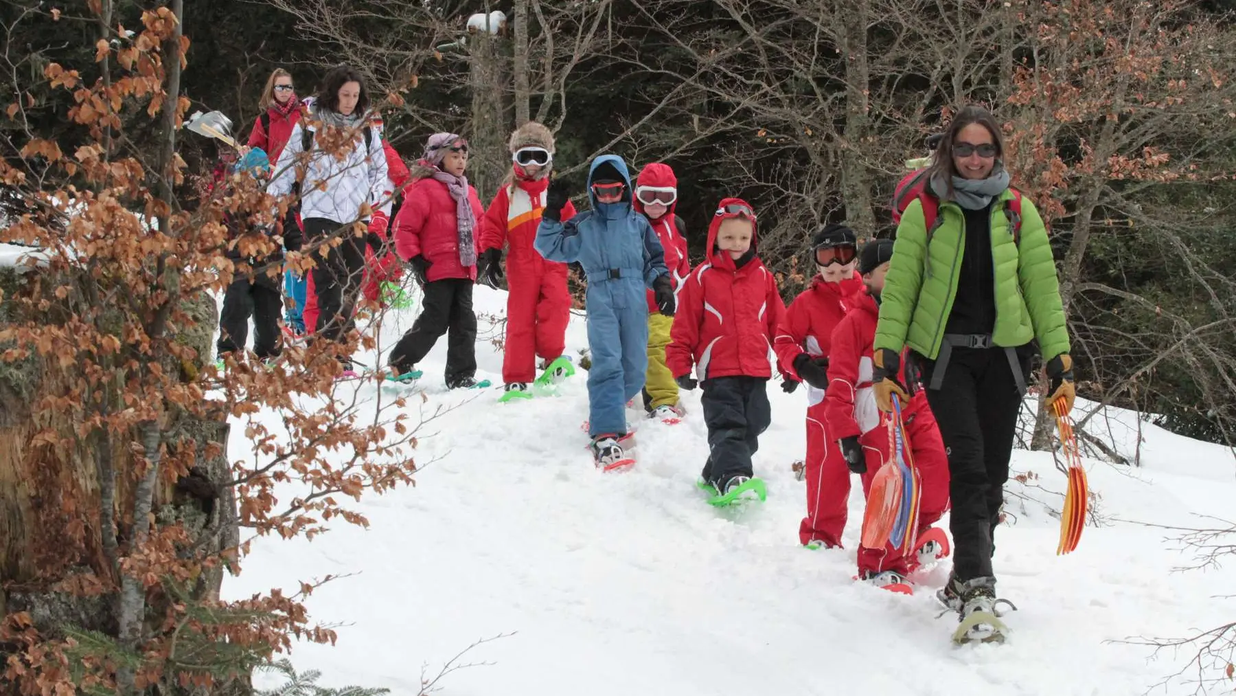 enfants à raquettes avec accompagnatrice en montagne