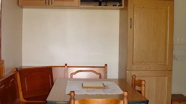 Séjour avec ameublement en bois, table à manger, espace de rangement, TV, carrelage au sol