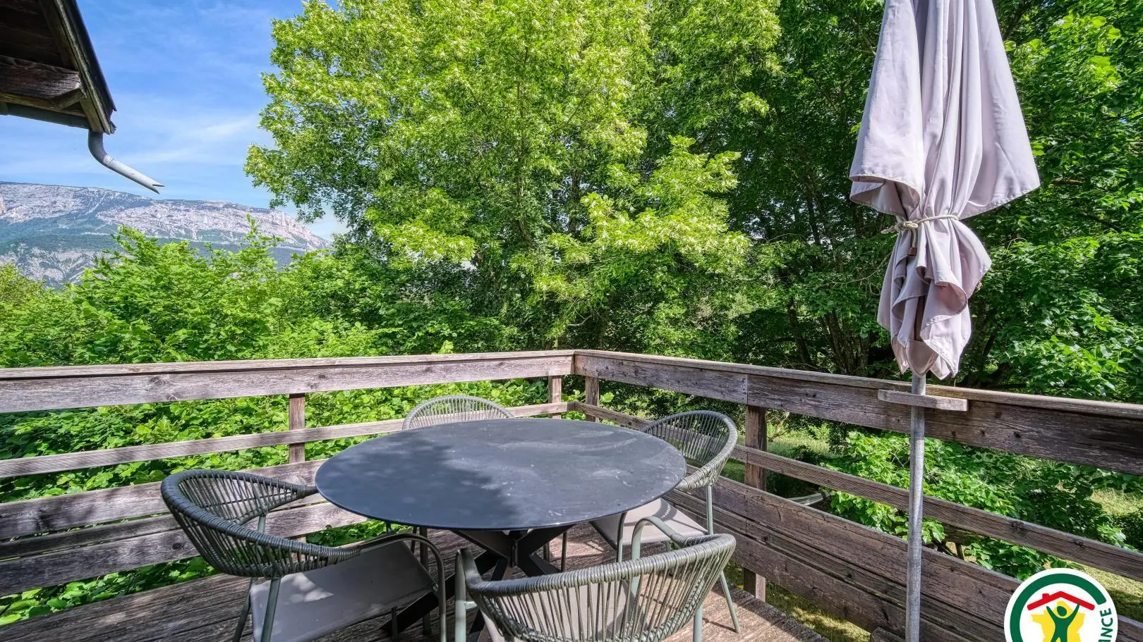 La terrasse fermée surplombant le jardin avec vue sur le massif du Glandasse (Vercors) et le plateau de Solaure