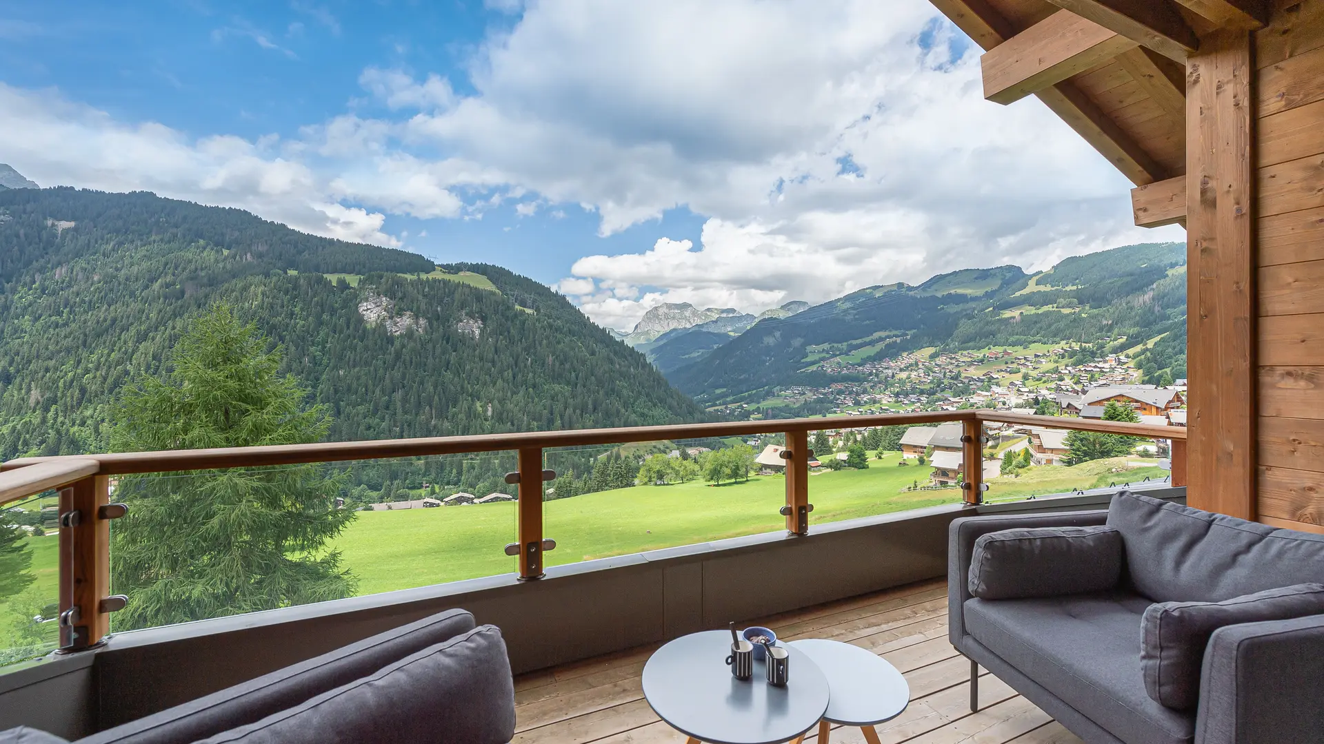 Balcon terrasse avec son mobilier de jardin et vue panoramique sur le village et les montagnes