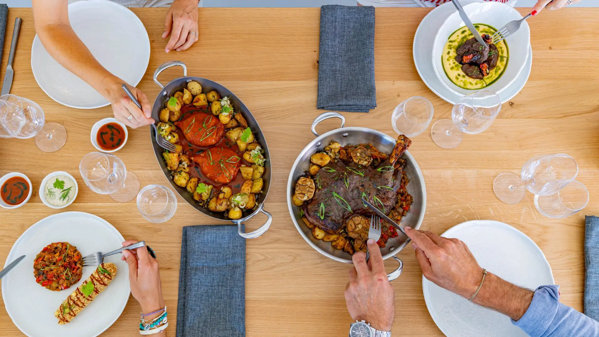 4 personnes a table qui partagent des plats