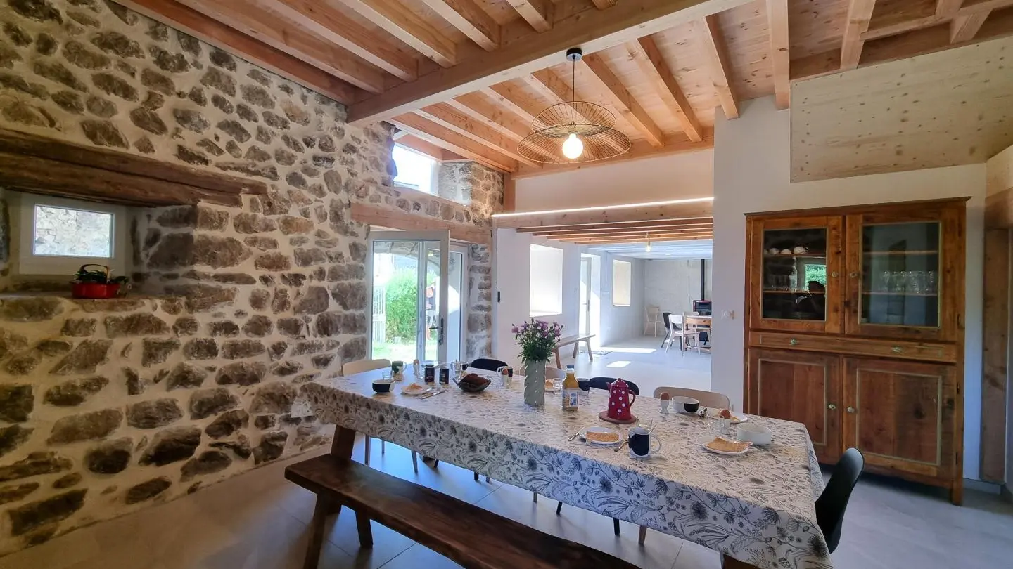 Pièce à vivre spacieuse avec cuisine intégrée ouverte sur un espace repas et sur la salle à manger.
