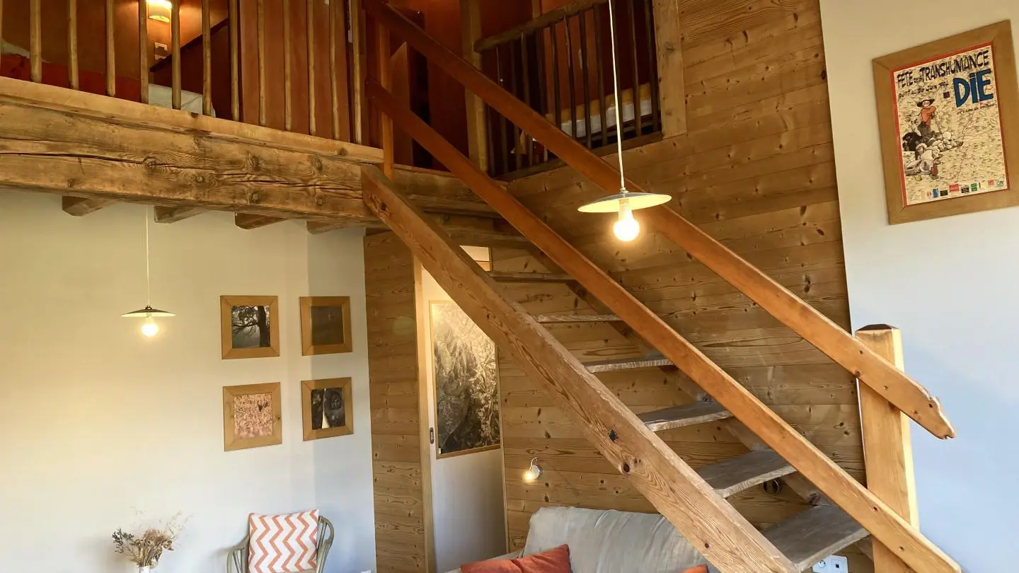 Les escaliers menant à la mezzanine et à la chambre. Une barrière de sécurité est disponible pour le haut des escaliers.