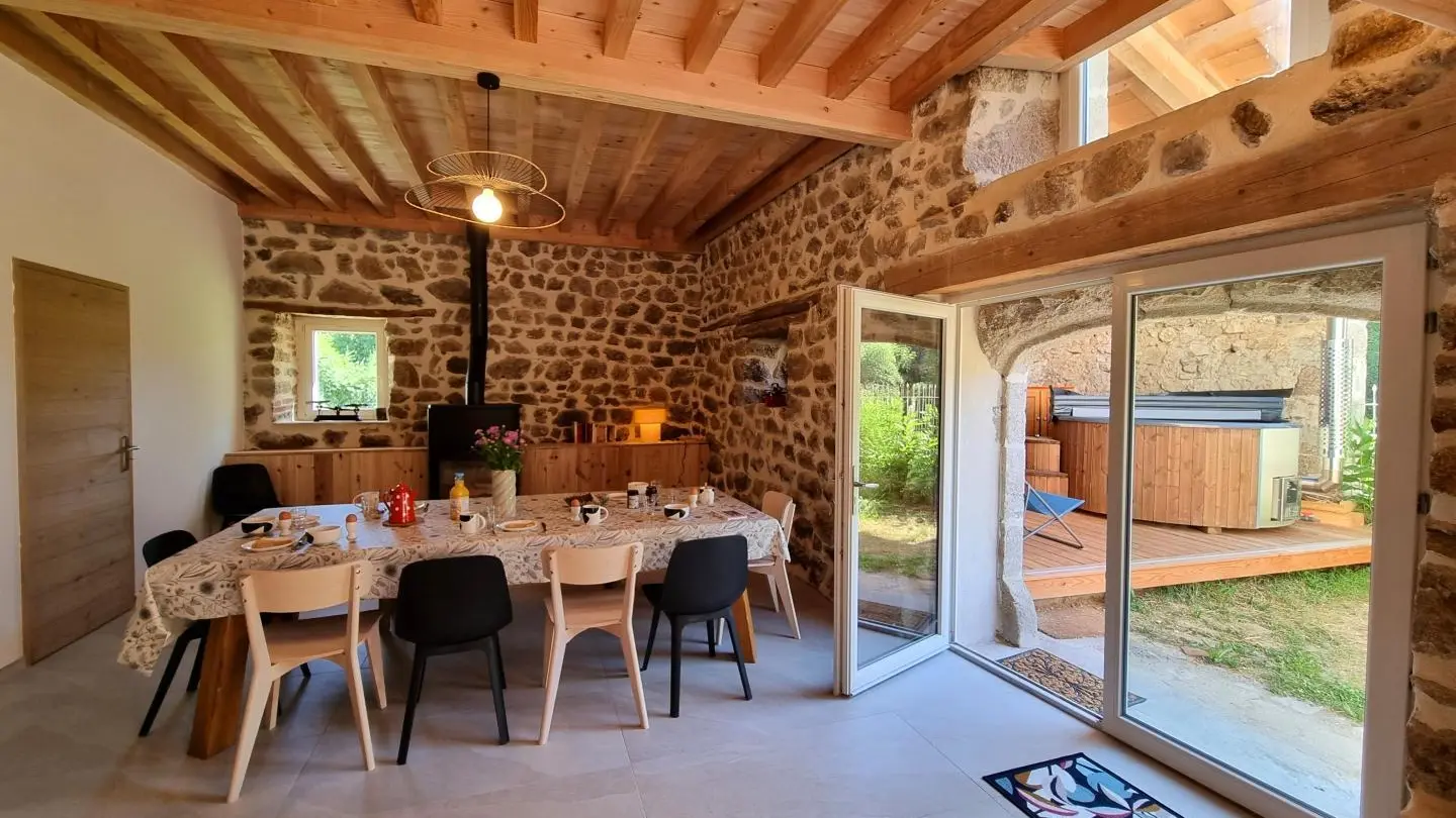 Pièce à vivre spacieuse avec cuisine intégrée ouverte sur un espace repas et sur la salle à manger.
