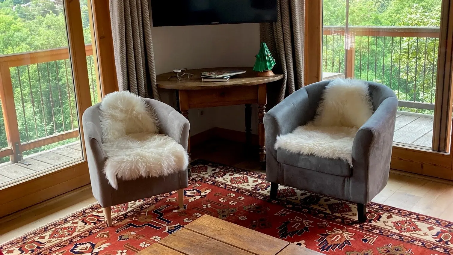 Avec 2 fauteuils, un canapé, 1 tv connectée, une table basse avec vue sur balcon en angle
