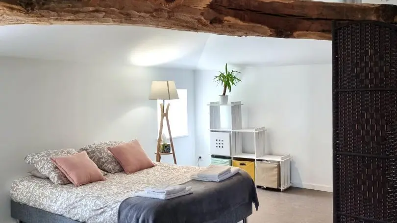 Chambre familiale 4 pers. sous combles, avec belle charpente apparente. Située au-dessus des 3 autres chambres, isolation phonique limitée.