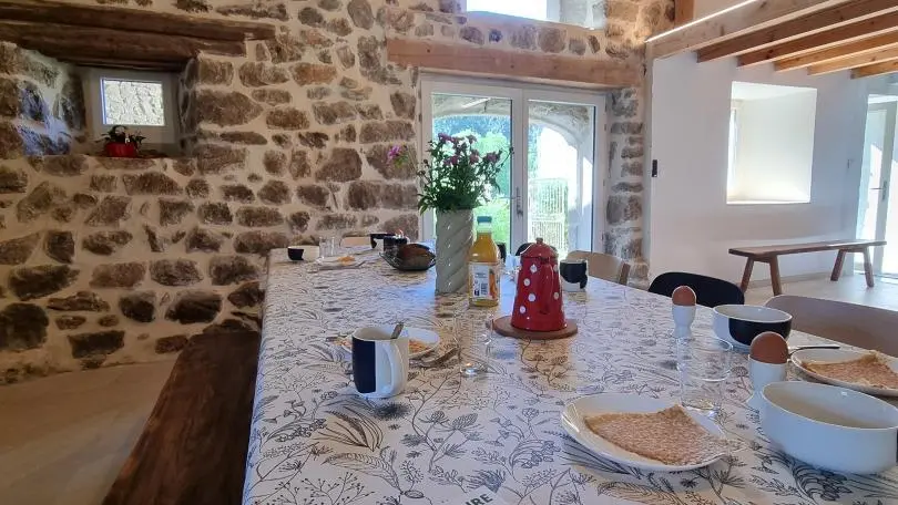 Pièce à vivre spacieuse avec cuisine intégrée ouverte sur un espace repas et sur la salle à manger.
