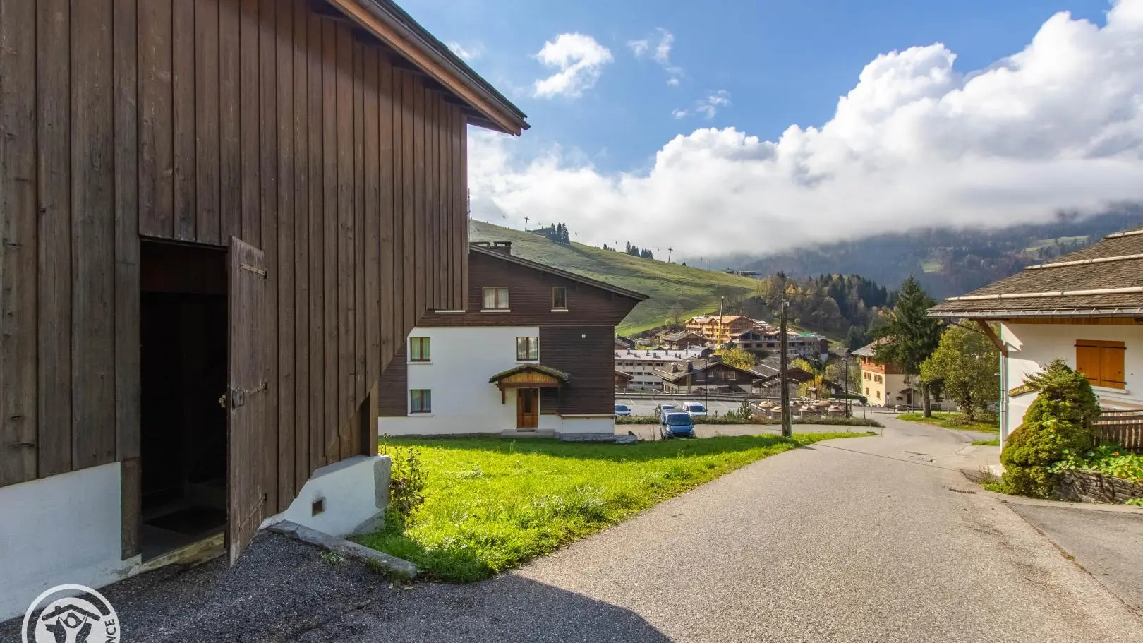 Accès au chalet avec vue sur les pistes de ski et les prés en été