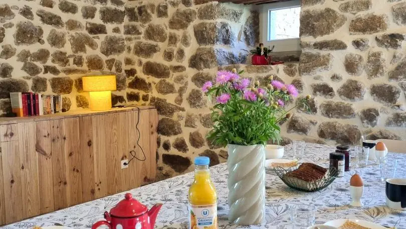 Pièce à vivre spacieuse avec cuisine intégrée ouverte sur un espace repas et sur la salle à manger.