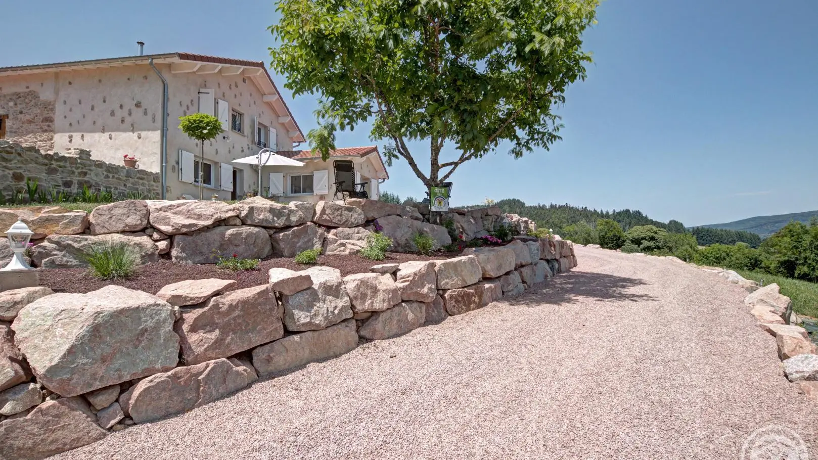 Le chemin d'accès avec son enrochement parsemé de rosiers