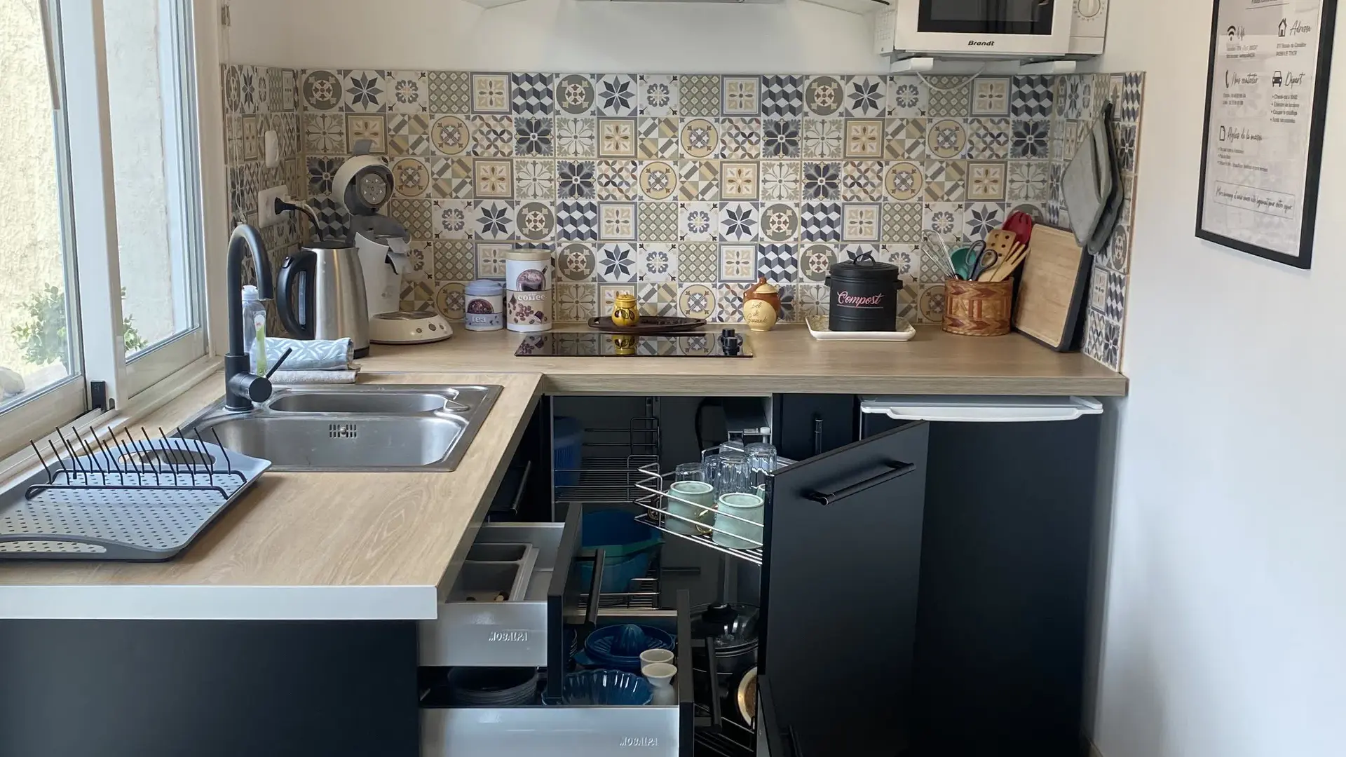 Cuisine moderne entièrement équipée avec rangements optimisés et électroménager fonctionnel.