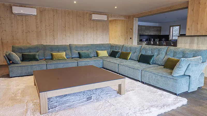 Large, comfortable and bright chalet living room, large corner sofa, rug, coffee table, wooden furniture