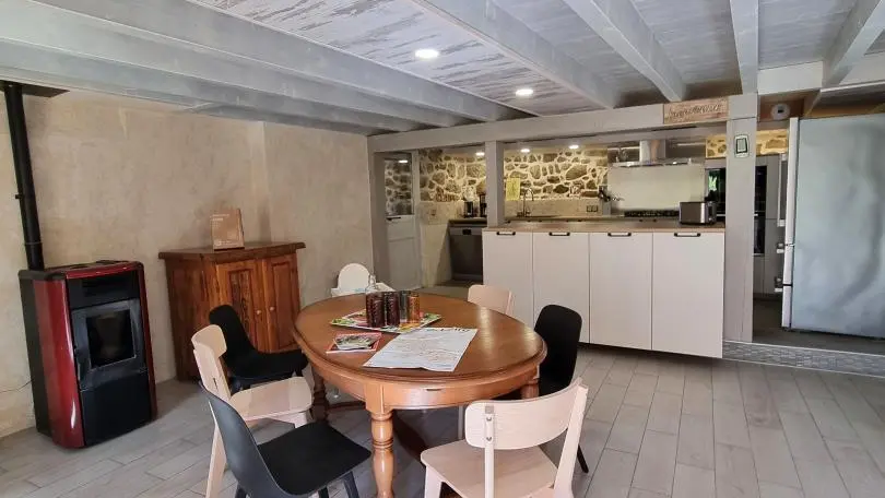 Pièce à vivre spacieuse avec cuisine intégrée ouverte sur un espace repas et sur la salle à manger.