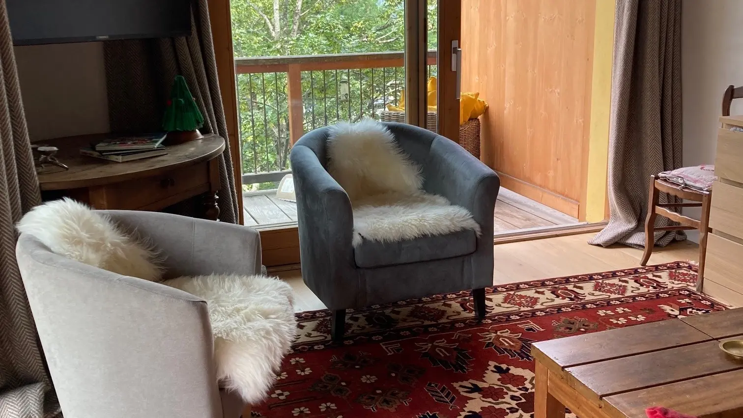 avec 2 fauteuils, tv connectée donnant accès sur un balcon