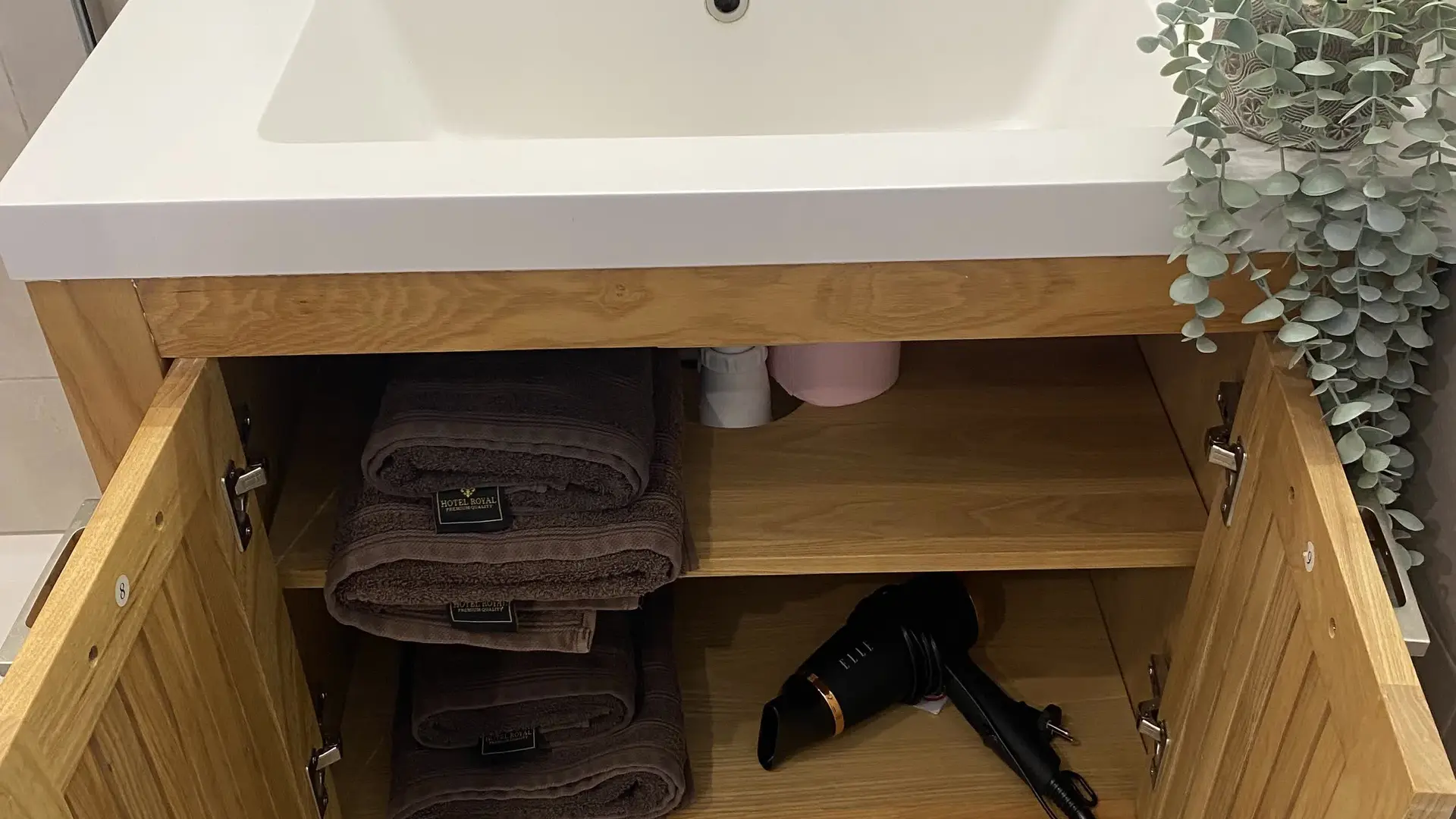 Meuble vasque avec rangements intégrés, linge de toilette et équipements à disposition.