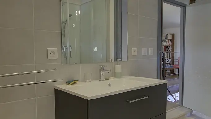 La salle d'eau avec cabine de douche et toilette.