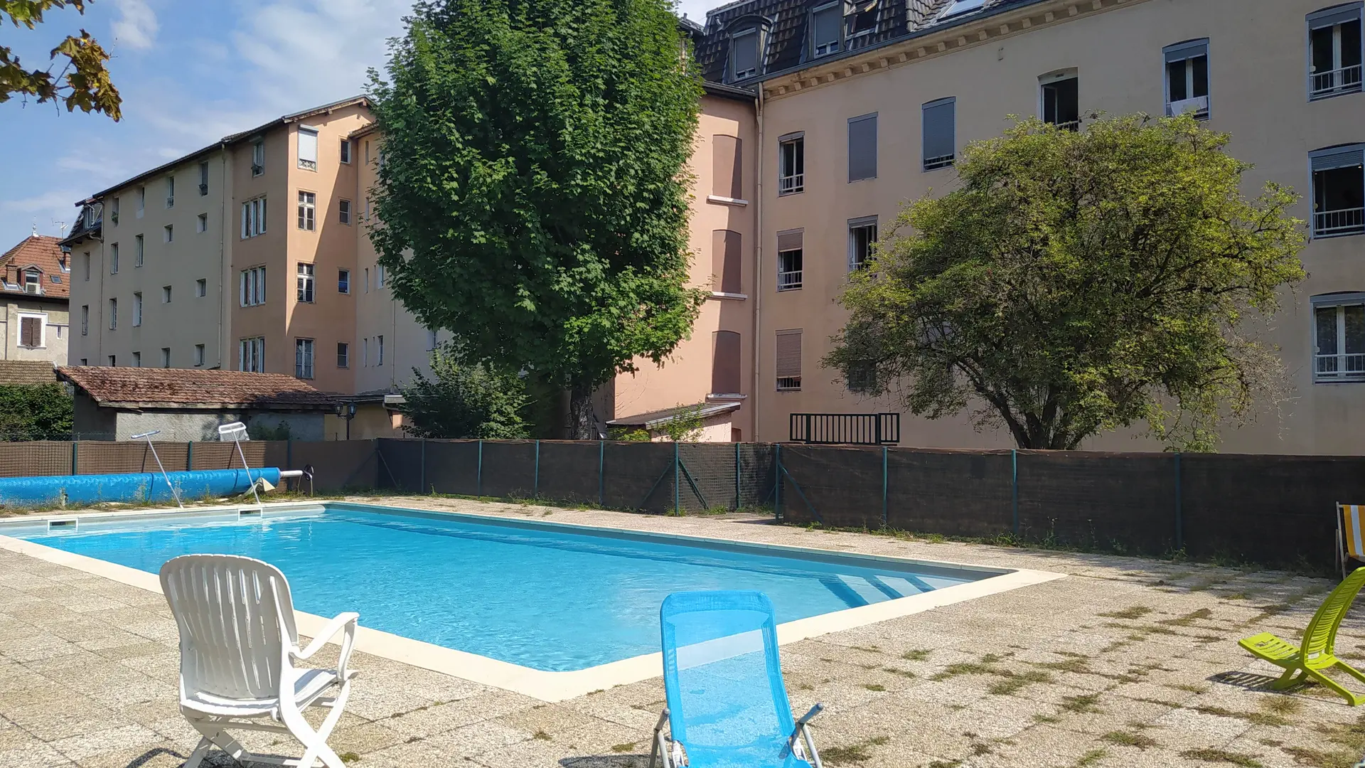 L’immeuble Le Globe abrite une cour intérieure avec une piscine et des chaises longues.