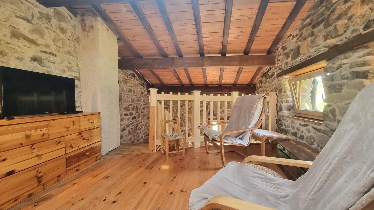 Mezzanine aménagée en chambre et espace salon/tv.