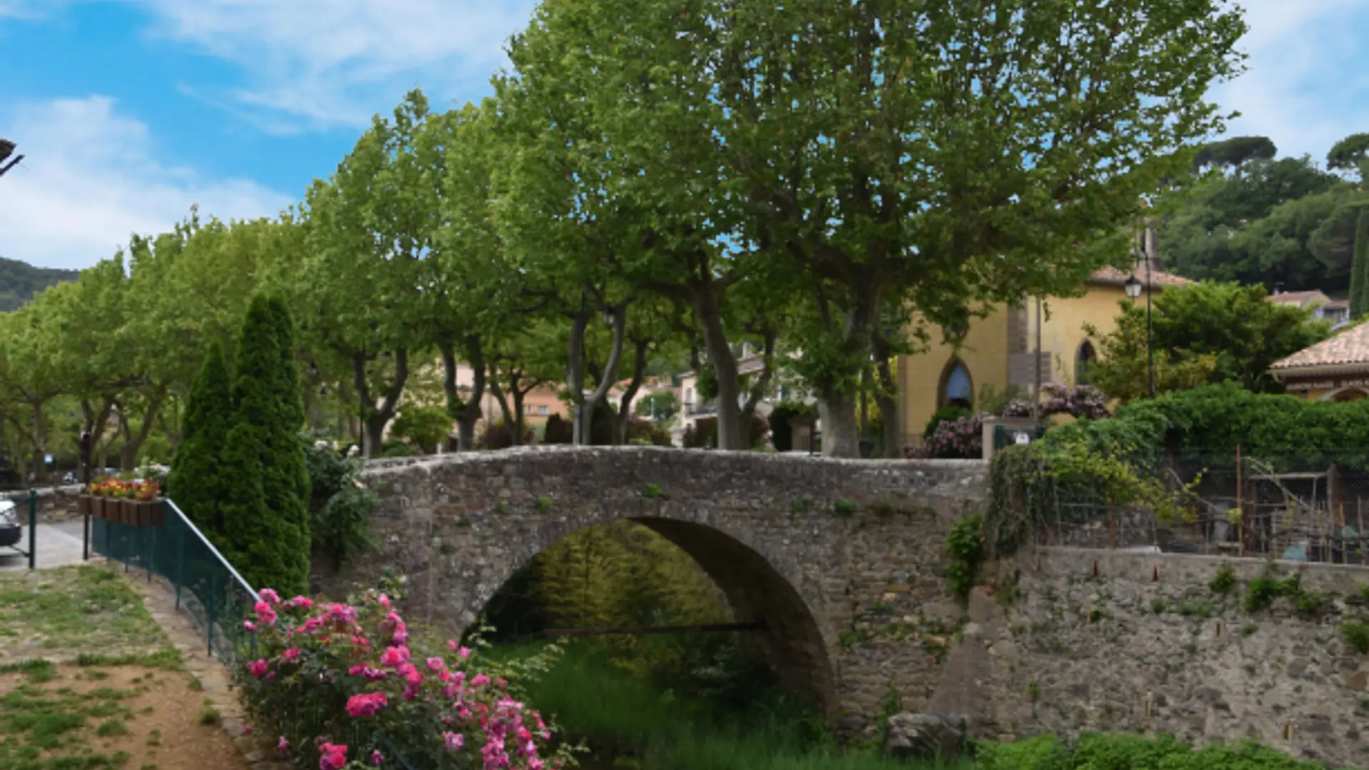 Vue sur le pont en pierre et les grands platanes du centre du village de Collobrières