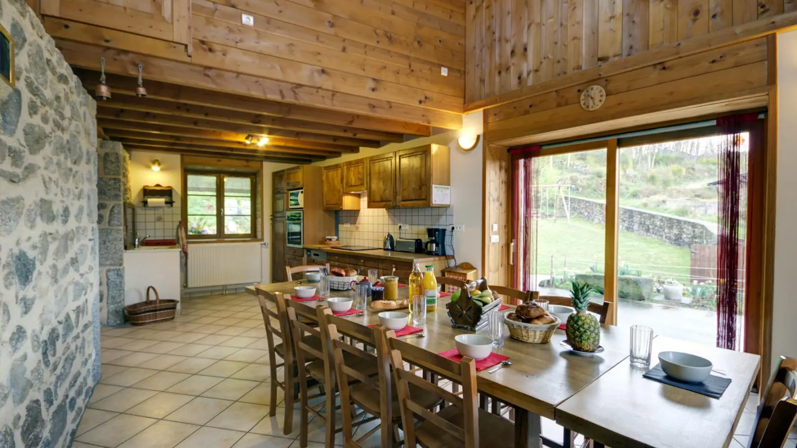 Cuisine équipée et salle à manger avec une grande table pour 10-12 personnes.