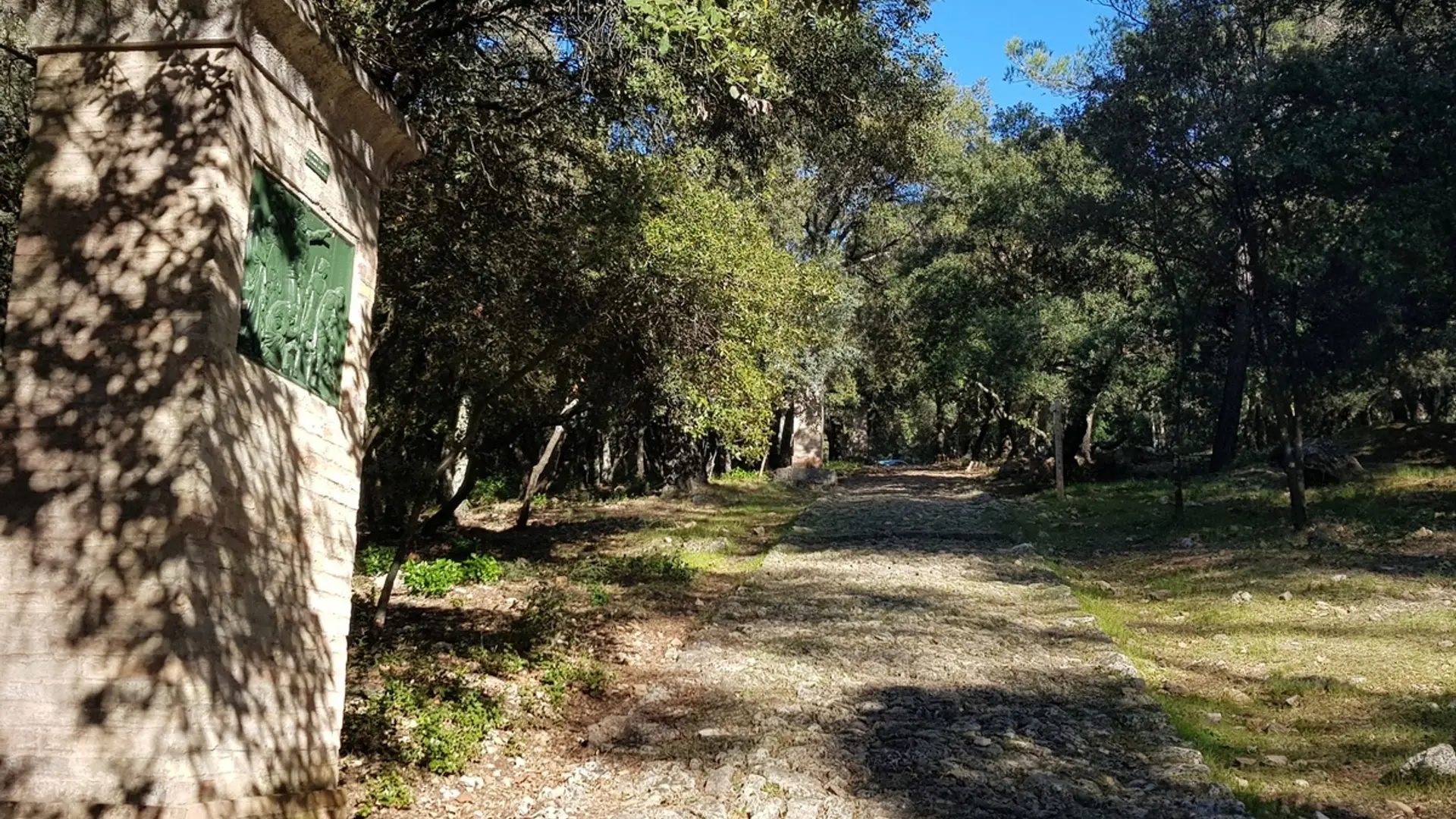 Vue sur les escaliers en pierre cheminant vers le sommet et un oratoire sur la gauche