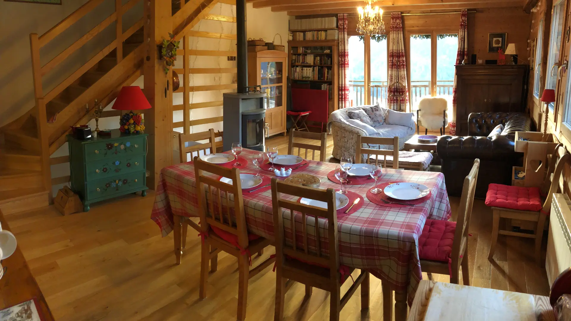 Séjour avec une table à manger, un poêle à bois, deux canapés