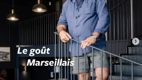 capture instagram du commerce avec didier tani debout dans un escalier à colimaçon