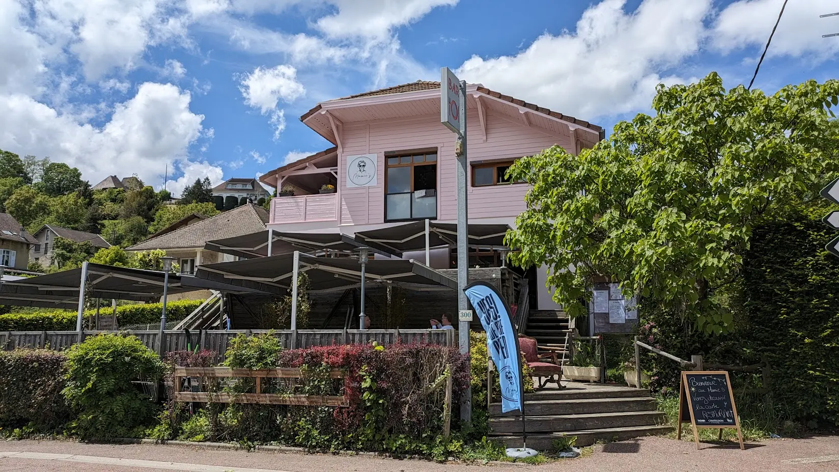 Vue du bâtiment depuis la rue : une façace rose pale est ornée d'une pastille représentant une grand-mère avec le nom de l'établissement 