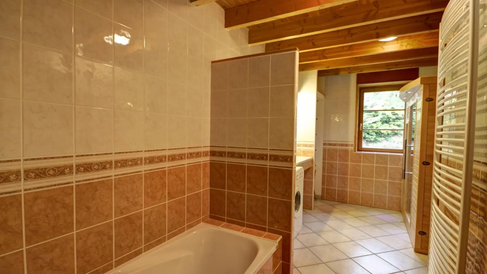 Salle de bain au rez-de-chaussée avec baignoire, douche italienne et sauna.