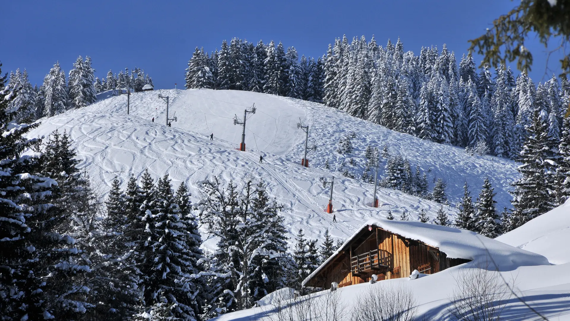 Piste retour et ses chalets traditionnels et vue sur le téléski de la Corne