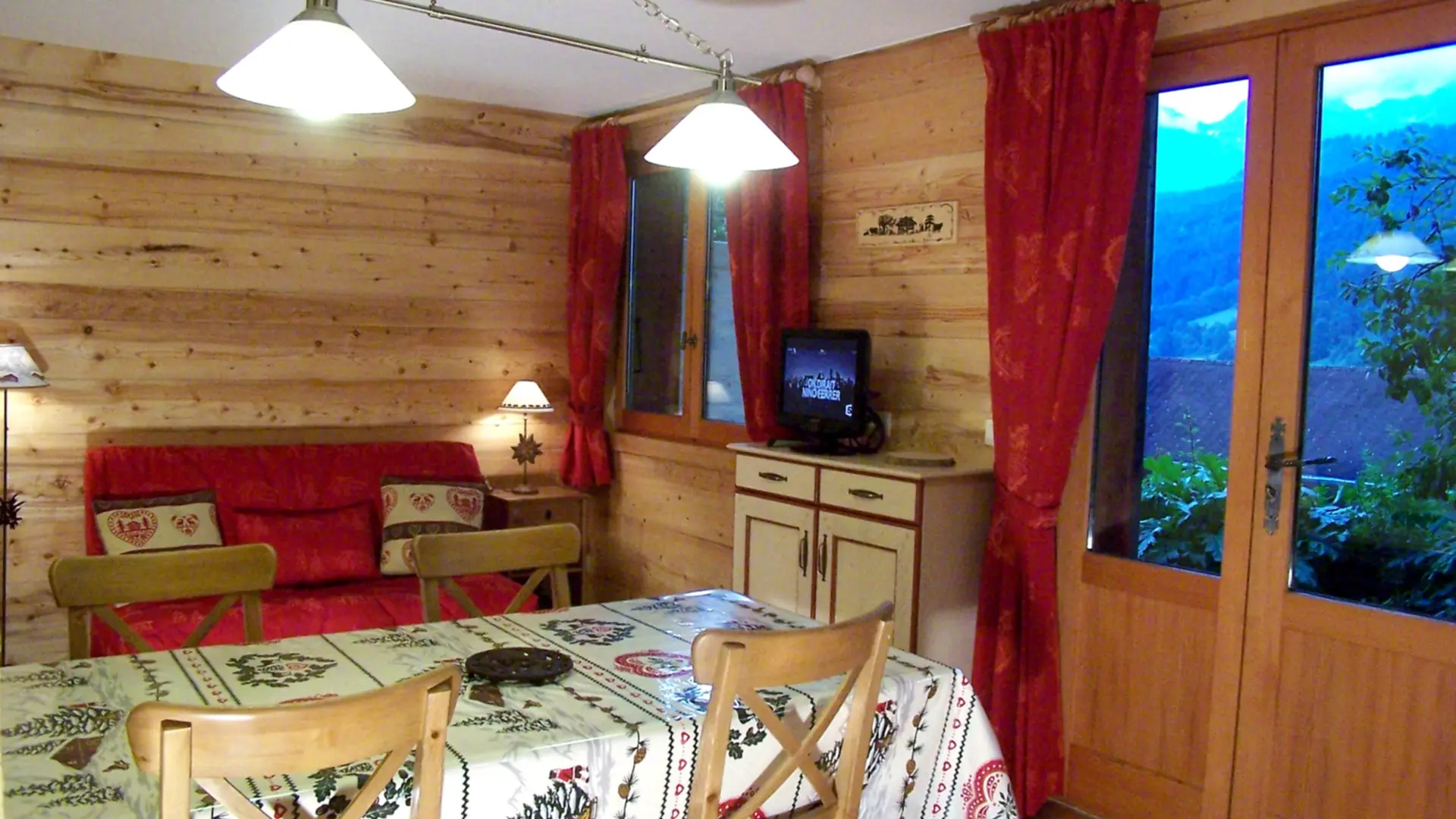 Séjour avec canapé et télévision, salle à manger/Living room with a sofa and a television, dining room-Buissière n°2-Le Grand-Bornand