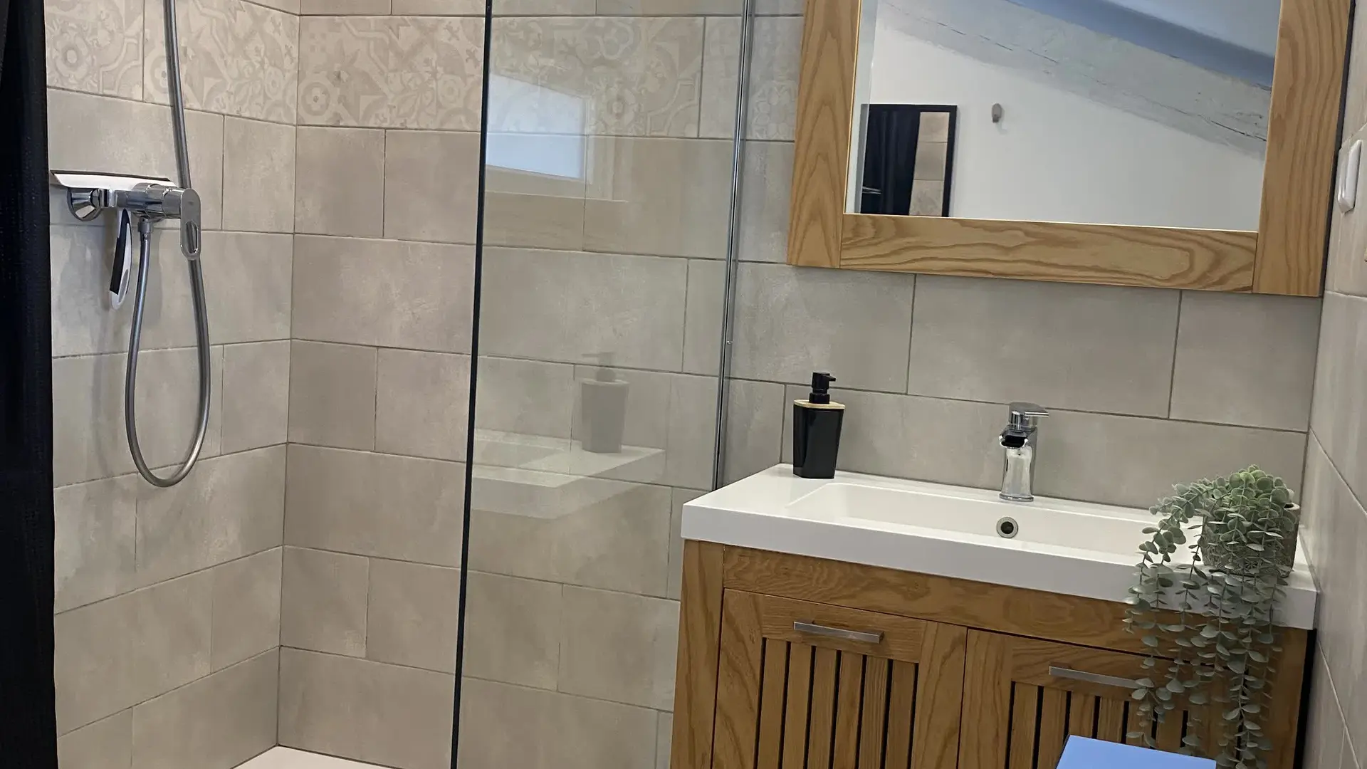 Douche moderne et spacieuse avec paroi vitrée et équipements contemporains.