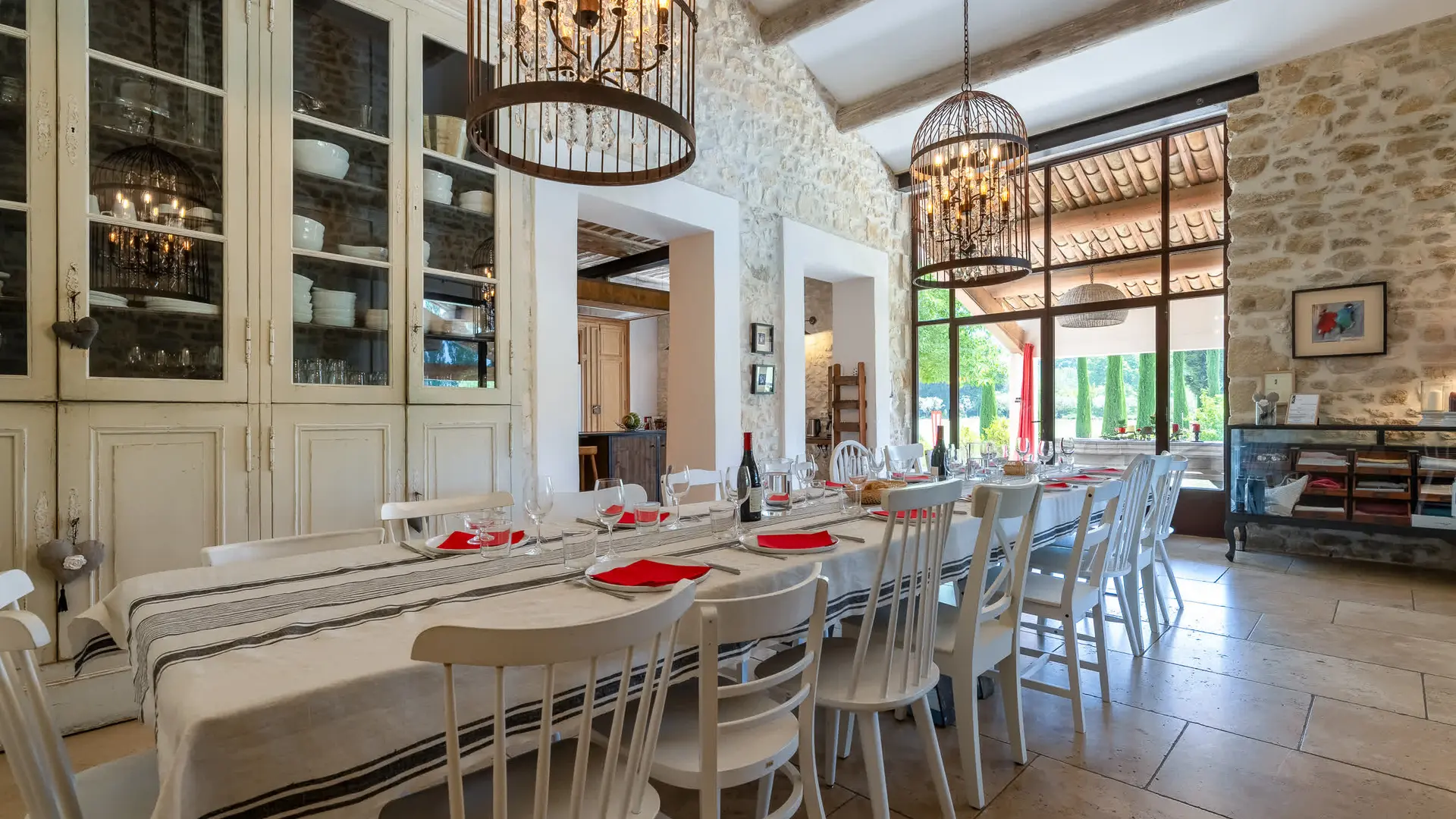 Salle à manger intérieure avec murs en pierre, grande table et suspensions élégantes.