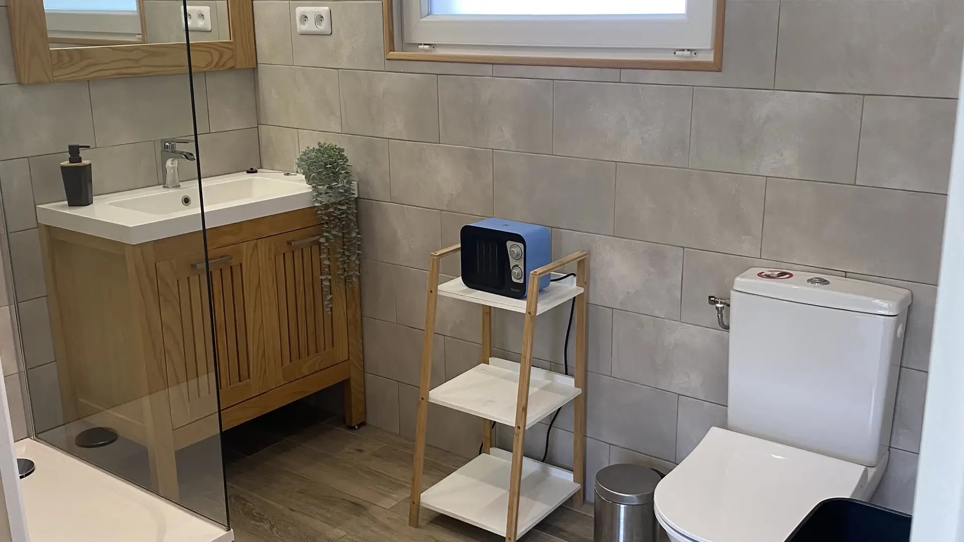 Salle de bain élégante mêlant bois et teintes naturelles, fonctionnelle et lumineuse.