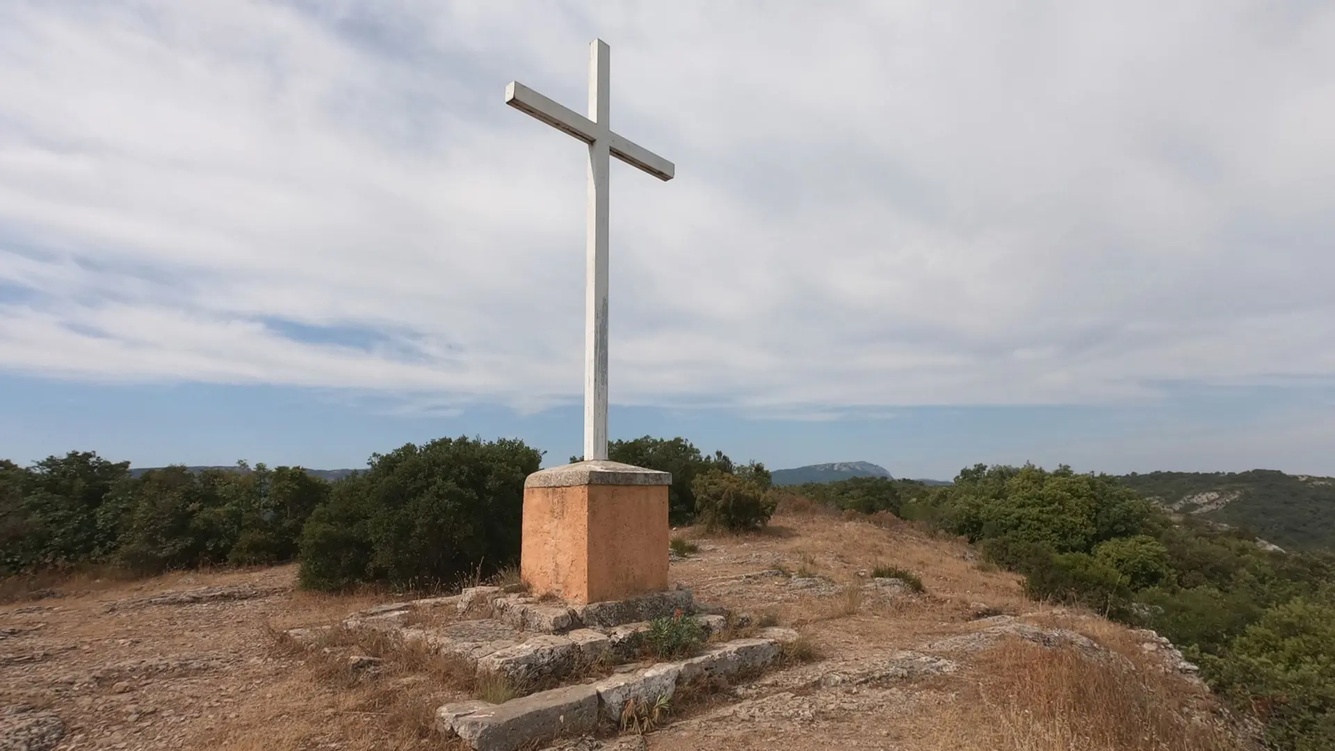 Croix blanche édifiée sur un plot béton à quelques mètres de la chapelle