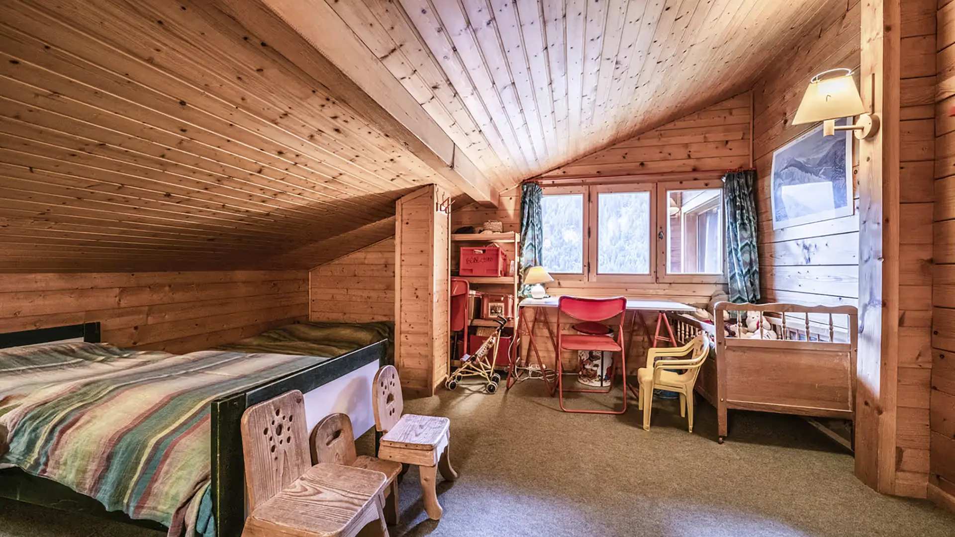 Chambre mansardée avec deux lits, bureau sous la fenêtre