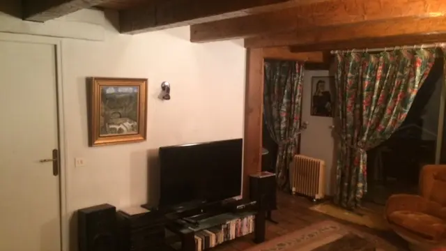 Séjour avec canapé, fauteuil, TV, tapis, fenêtre